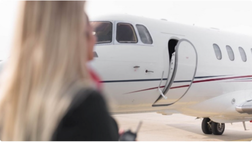 Passenger approaching a private jet with the aircraft door open for boarding